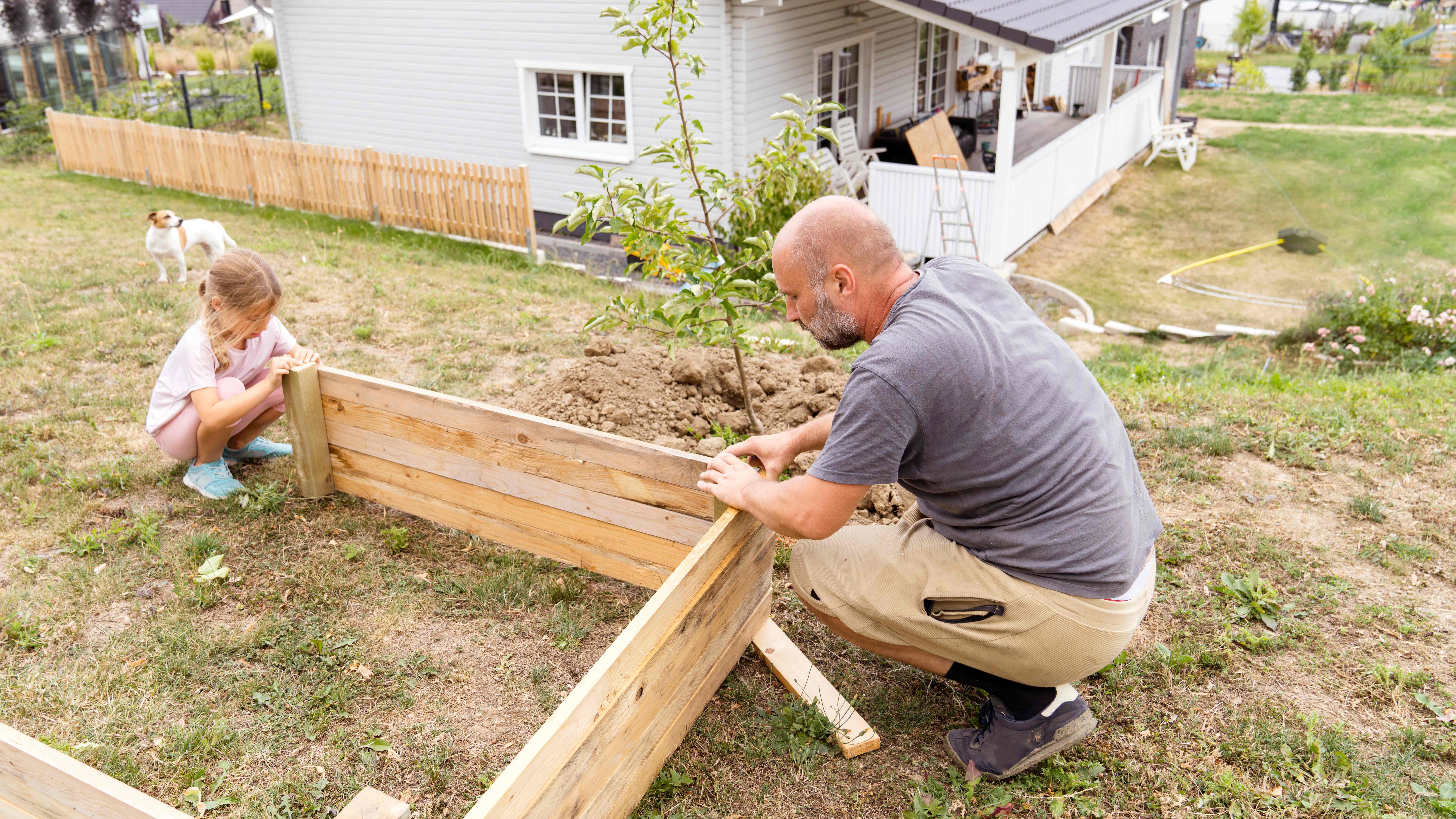 Father and daughter making a raised garden bed 